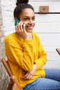 Beautiful young african american woman at cafe using cellphone Royalty Free Stock Photo