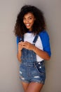 Beautiful young african american woman with curly hair holding mobile phone Royalty Free Stock Photo