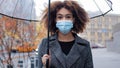 Beautiful young African American woman girl with curly hair with transparent umbrella stands in city on street autumn Royalty Free Stock Photo