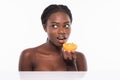 Beautiful young african american woman isolated on white background. Afro girl and diet concept with orange fruit. Copy space. Royalty Free Stock Photo