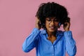 beautiful young African american woman listening music in headphones  on pink background Royalty Free Stock Photo