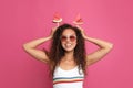 Beautiful young African American woman with pieces of watermelon on crimson background