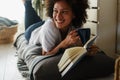 Beautiful young African American woman reading a book at home Royalty Free Stock Photo