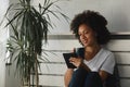 Beautiful young African American woman reading a book at home Royalty Free Stock Photo