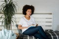 Beautiful young African American woman reading a book at home Royalty Free Stock Photo