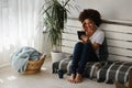 Beautiful young African American woman reading an ebook at home Royalty Free Stock Photo