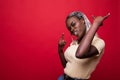 Beautiful young african american woman shouting with crazy expression doing rock symbol with hands up over red isolated background Royalty Free Stock Photo