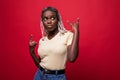 Beautiful young african american woman shouting with crazy expression doing rock symbol with hands up over red isolated background Royalty Free Stock Photo