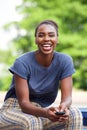 Beautiful young african american woman sitting outdoors with mobile phone Royalty Free Stock Photo