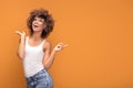 Cheerful afro woman points her fingers on yellow background. Royalty Free Stock Photo