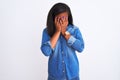 Beautiful young african american woman wearing denim jacket over isolated background with sad expression covering face with hands Royalty Free Stock Photo