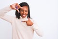 Beautiful young african american woman wearing turtleneck sweater over isolated background smiling making frame with hands and Royalty Free Stock Photo