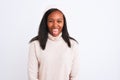 Beautiful young african american woman wearing turtleneck sweater and winter hat sticking tongue out happy with funny expression Royalty Free Stock Photo