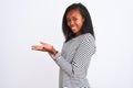 Beautiful young african american woman wearing winter sweater over isolated background pointing aside with hands open palms Royalty Free Stock Photo