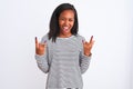 Beautiful young african american woman wearing winter sweater over isolated background shouting with crazy expression doing rock Royalty Free Stock Photo