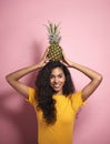 Beautiful African woman holding a pineapple on her head Royalty Free Stock Photo