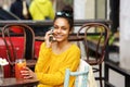 Beautiful young african woman using cell phone at cafe Royalty Free Stock Photo