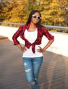 Beautiful young african woman wearing sunglasses and red checkered shirt in city Royalty Free Stock Photo