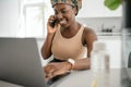 Black African traditional woman working from home wearing headscarf Royalty Free Stock Photo