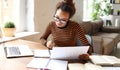 Focused smart young african american woman working online on laptop or female student studying online at home Royalty Free Stock Photo