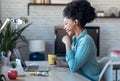 Beautiful young afro business woman making video call with laptop while drinking coffee sitting in the office at home Royalty Free Stock Photo