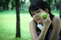 Beautiful Asia sport woman holding green apples and walking in public park