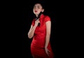 beautiful young Asia woman red dress traditional cheongsam holding gun at the black background Royalty Free Stock Photo