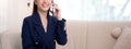 Beautiful young asian adviser or business woman talking on smartphone and smile while relax in the living room. Royalty Free Stock Photo