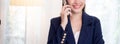 Beautiful young asian adviser or business woman talking on smartphone and smile while relax in the living room. Royalty Free Stock Photo