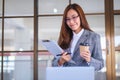 A beautiful young asian business woman drinking coffee and using laptop computer while working in office Royalty Free Stock Photo