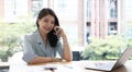 Beautiful young Asian businesswoman charming smiling and talking on the mobile phone in the office. Royalty Free Stock Photo