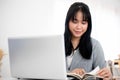 A beautiful young Asian businesswoman or secretary working at her desk in a modern bright office Royalty Free Stock Photo