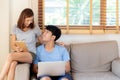 Beautiful young asian couple cheerful freelance working with man using laptop and woman using tablet on couch Royalty Free Stock Photo