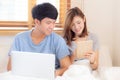 Beautiful young asian couple cheerful freelance working with man using laptop and woman using tablet on couch Royalty Free Stock Photo