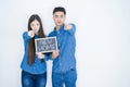 Beautiful young asian couple over white background holding blackboard with new home text pointing with finger to the camera and to Royalty Free Stock Photo