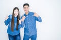Beautiful young asian couple over white isolated background shouting with crazy expression doing rock symbol with hands up Royalty Free Stock Photo