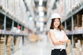 Beautiful young Asian engineer or technician smiling, warehouse or factory blur background, industry or logistic concept