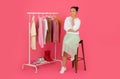 Beautiful Young Asian Fashion Stylist Woman Sitting On Chair Near Clothing Rack