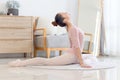 Beautiful young Asian female ballerina practicing ballet dance in the living room. Flexible ballet woman dancer doing stretching Royalty Free Stock Photo