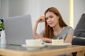 Beautiful young Asian female using laptop computer to research something Royalty Free Stock Photo