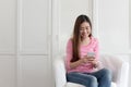 Beautiful young of Asian girl using a smartphone while sitting on the sofa in the living room at home, Asia women happy smile Royalty Free Stock Photo