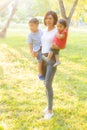 Beautiful young asian mother carrying little boy and girl in the park, asia woman happy having son and daughter and hug kid Royalty Free Stock Photo