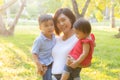 Beautiful young asian mother carrying little boy and girl in the park, asia woman happy having son and daughter and hug kid Royalty Free Stock Photo