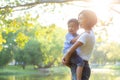 Beautiful young asian mother carrying little boy in the park, asia woman happy having son and hug kid Royalty Free Stock Photo