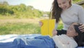Beautiful young asian mother and daughter doing picnic and reading tale in yellow books at green park. Royalty Free Stock Photo