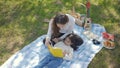 Beautiful young asian mother and daughter doing picnic and reading tale in yellow books at green park. Royalty Free Stock Photo