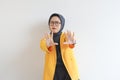 Beautiful young Asian Muslim woman, wearing glasses and yellow blazer with scared face expression Royalty Free Stock Photo