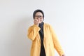 Beautiful young Asian Muslim woman, wearing glasses and yellow blazer with scared face expression Royalty Free Stock Photo