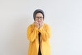 Beautiful young Asian Muslim woman, wearing glasses and yellow blazer with scared face expression Royalty Free Stock Photo