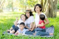 Beautiful young asian parent family portrait picnic in the park, kid or children and mother love happy and cheerful together Royalty Free Stock Photo